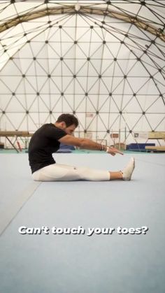 a man is sitting on the floor stretching