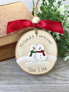 a wooden ornament with two snowmen on it and the words friends forever you're me