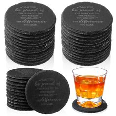 a stack of black coasters next to a glass filled with tea