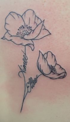 the back of a woman's shoulder with flowers on it and name written in cursive writing