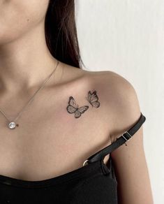 a woman's chest with two butterflies on her left shoulder and the other arm