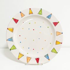 a white plate with multicolored party hats on the front and sides, against a white background