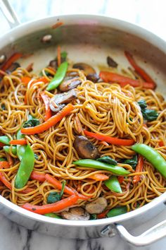 stir fry noodles with vegetables and mushrooms in a pan