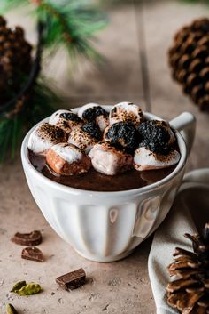 a white bowl filled with hot chocolate and marshmallows on top of a table