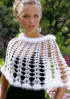 a woman wearing a white crochet shawl and earrings in front of flowers