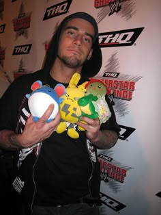 a man holding two stuffed animals in his hands