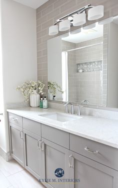 a bathroom with two sinks and a large mirror on the wall above it is white tile