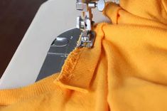 the sewing machine is working on the yellow fabric