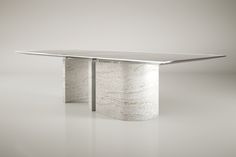 a white marble dining table with an oval base and silver metal legs, on a grey background