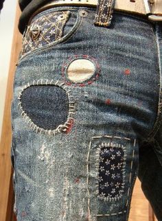 a pair of jeans with holes in the back pocket and buttons on the inside of them