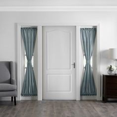 an empty room with two doors and a chair next to it on a hard wood floor