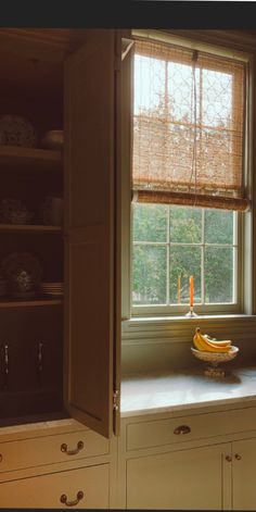 a kitchen window with a banana on the counter and other dishes in front of it