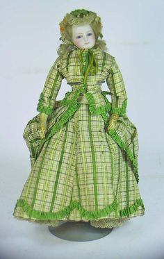 the doll is wearing a green dress with ruffles on it's skirt