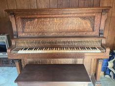 an old piano in a wood paneled room