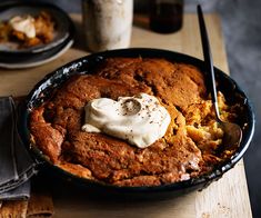 a skillet filled with food on top of a wooden table