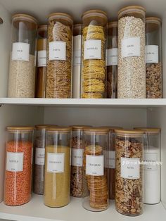 the shelves are filled with different types of cereal in glass containers and labeled labels on them