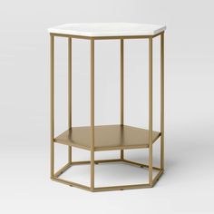 an octagonal side table with a white marble top and gold metal frame, in the shape of a hexagonal structure