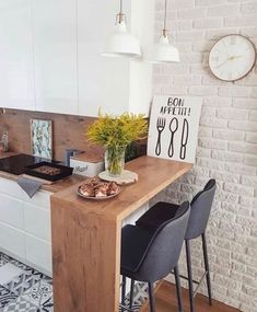 a kitchen with white brick walls and wooden counter tops, two chairs at the island