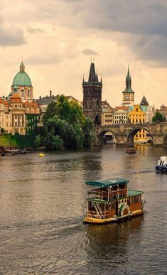 a boat traveling down a river next to tall buildings on either side of a bridge