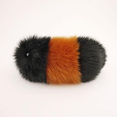 an orange, black and white striped animal tail on a white background with space for text