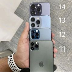 four iphones in different colors being held by someone