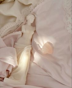 an unmade bed with white sheets and lace