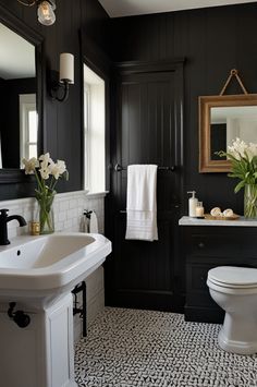 a white toilet sitting next to a sink in a bathroom under a mirror and lights