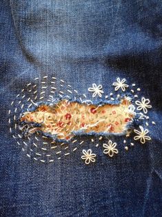 a piece of fabric with holes and flowers on it, in the back pocket of someone's jeans