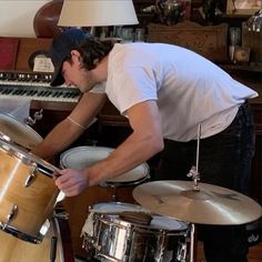 a man playing drums in front of a keyboard