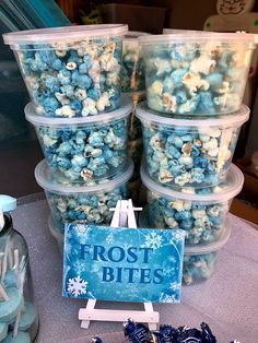 blue and white popcorn in plastic containers with frosted snowflakes on the table