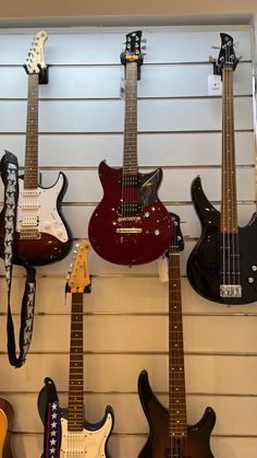 several guitars are lined up on the wall