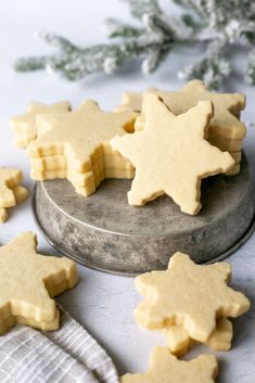 some cut out cookies are on a plate and next to a silver tray with white napkins