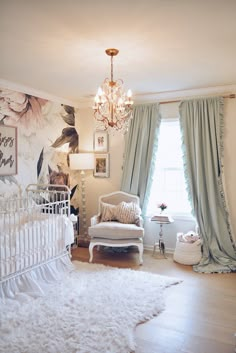 a baby's room with a white crib and chandelier