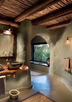 a bathroom with an oval sink and stone walls