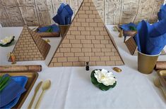 a table set up with blue napkins and place settings