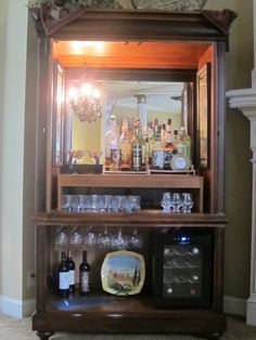 an old fashioned bar with wine glasses and bottles on it's display shelf in front of a mirror