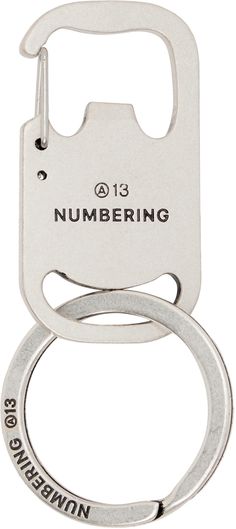 a silver bottle opener with the number 13 on it's front and back side