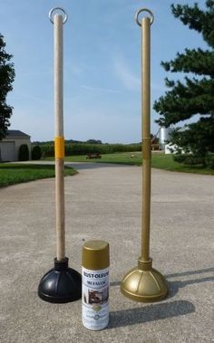 two metal and wood poles are standing next to each other on the pavement in front of some trees