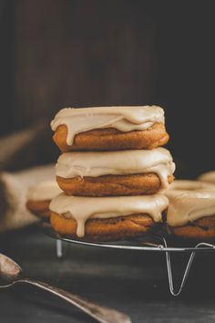 a stack of frosted donuts sitting on top of a metal rack