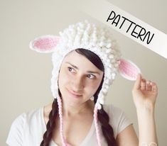 a woman wearing a knitted sheep hat with the word pattern over her head in front of her face