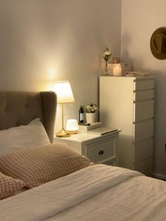 a bedroom with a bed, night stand and lamp on the nightstands next to it