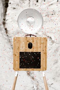 a wooden box with a satellite dish on top and confetti all around it