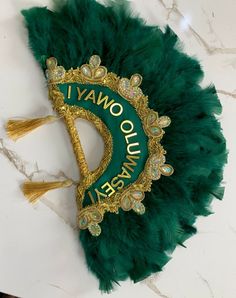 a green and gold mardi gras mask sitting on top of a marble counter