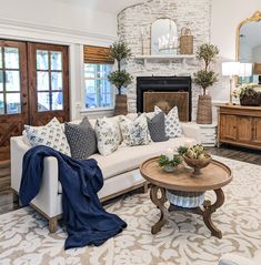 a living room filled with furniture and a fire place in front of a brick fireplace