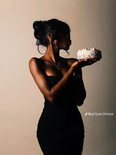 a woman in a black dress holding a piece of cake