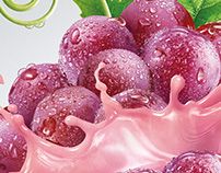 grapes with pink liquid splashing out of them and green leaves on the side, in front of a white background