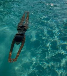 a man swimming in the water with his head above the water's surface as he swims