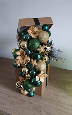 a box with ornaments in it sitting on a wooden table next to a planter