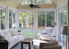 a living room filled with furniture and windows covered in white coverings on the ceiling