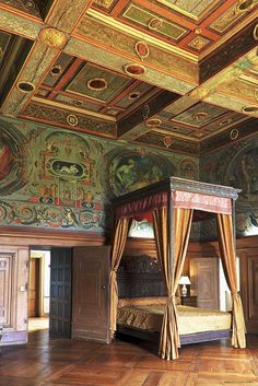 an ornate bedroom with painted ceilings and wooden floors